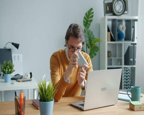 Man drinking water at office desk with good posture